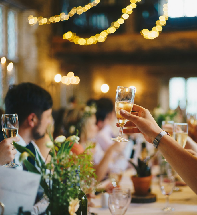 people raising wine glass in selective focus photography